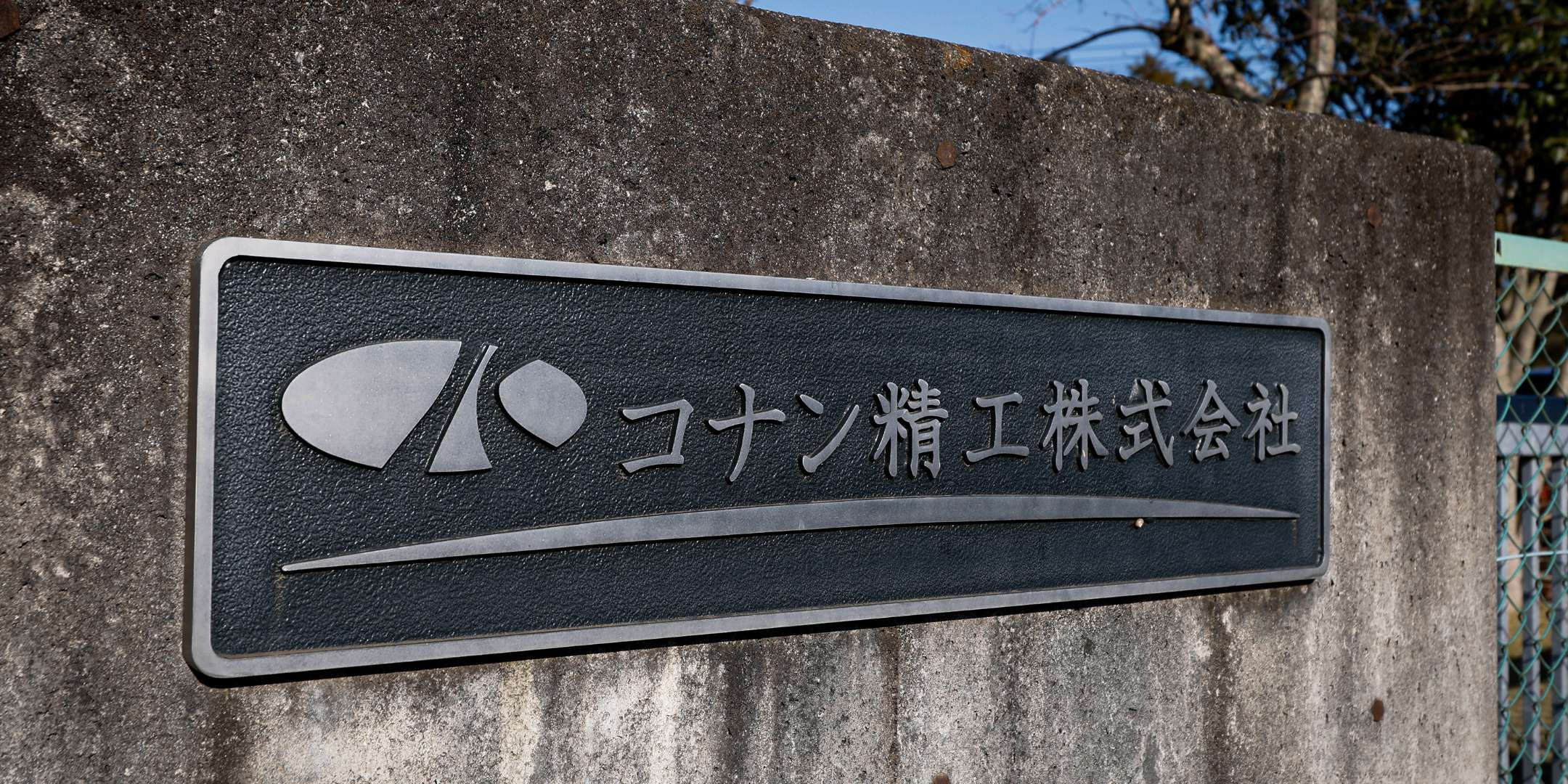 コナン精工株式会社の社名が刻まれた金属製の看板